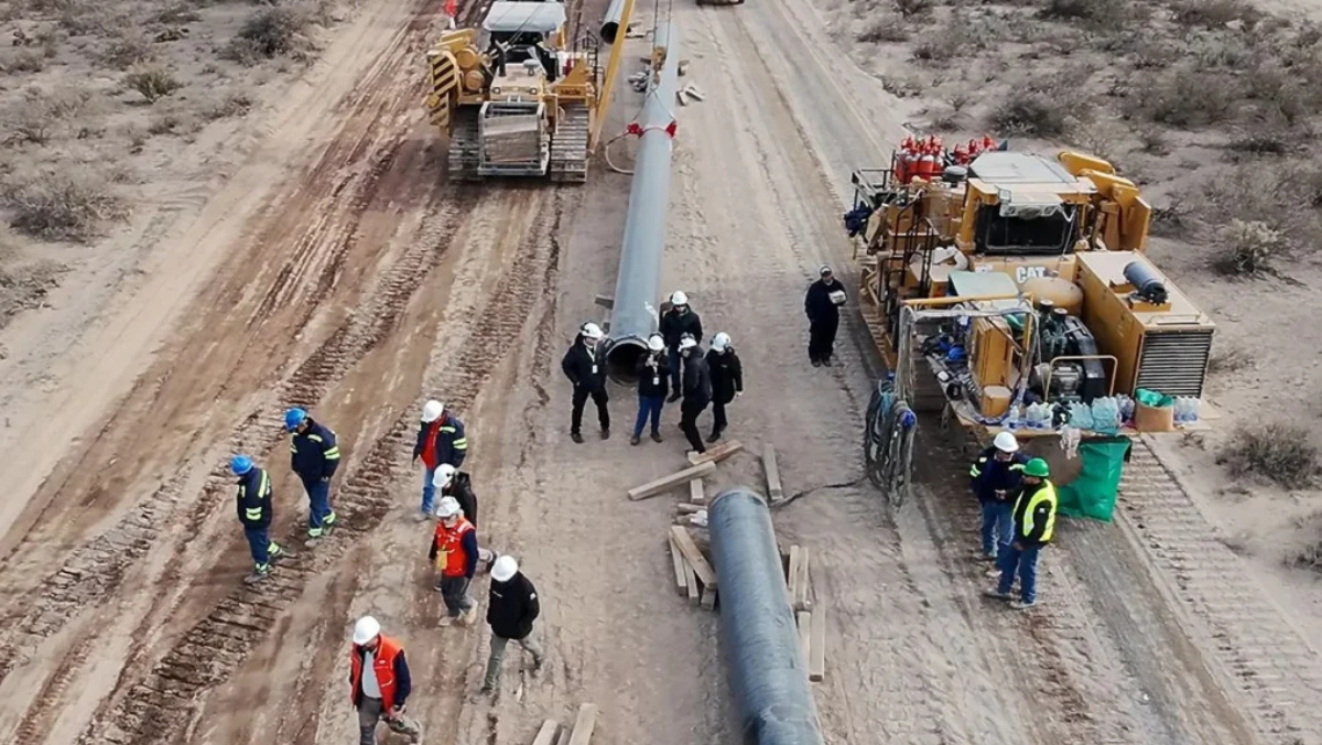 Oil and gas workers installing pipeline sections at a shale development site in Argentina.