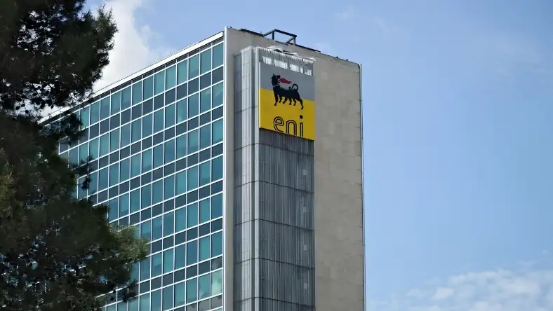 The Eni building showing the yellow-backed Eni logo on a grey concrete and glass tower under a blue sky